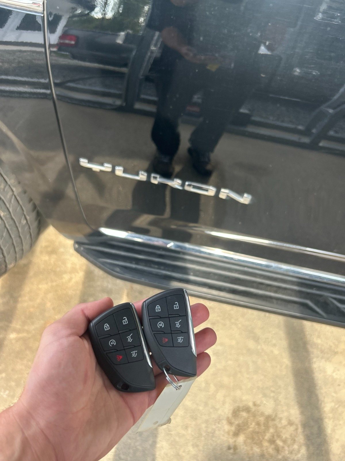 Programmed vehicle key fobs next to an SUV